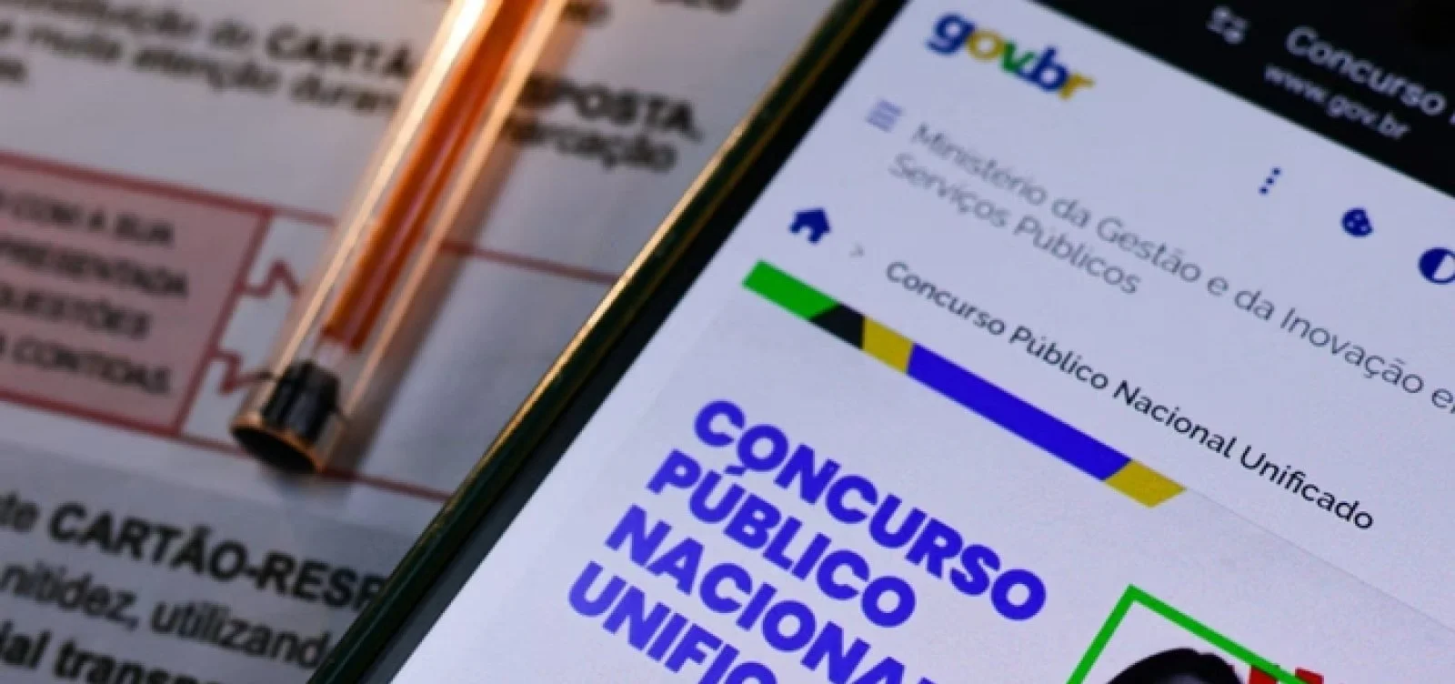 Pessoa vendo o site do CNU 2025 pelo celular.