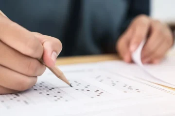 Mão escrevendo na prova do concurso CRBio 5.