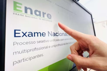 Dedo apontando para tela do computador, onde está a notícia do Enare 2025