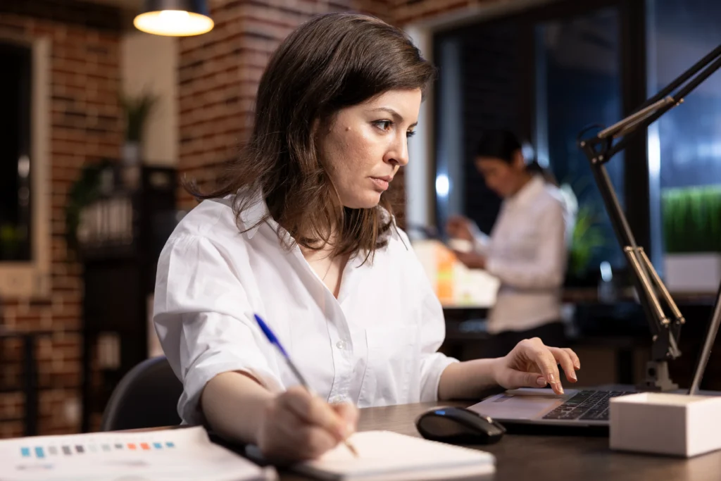 mulher escrevendo notas no computador 