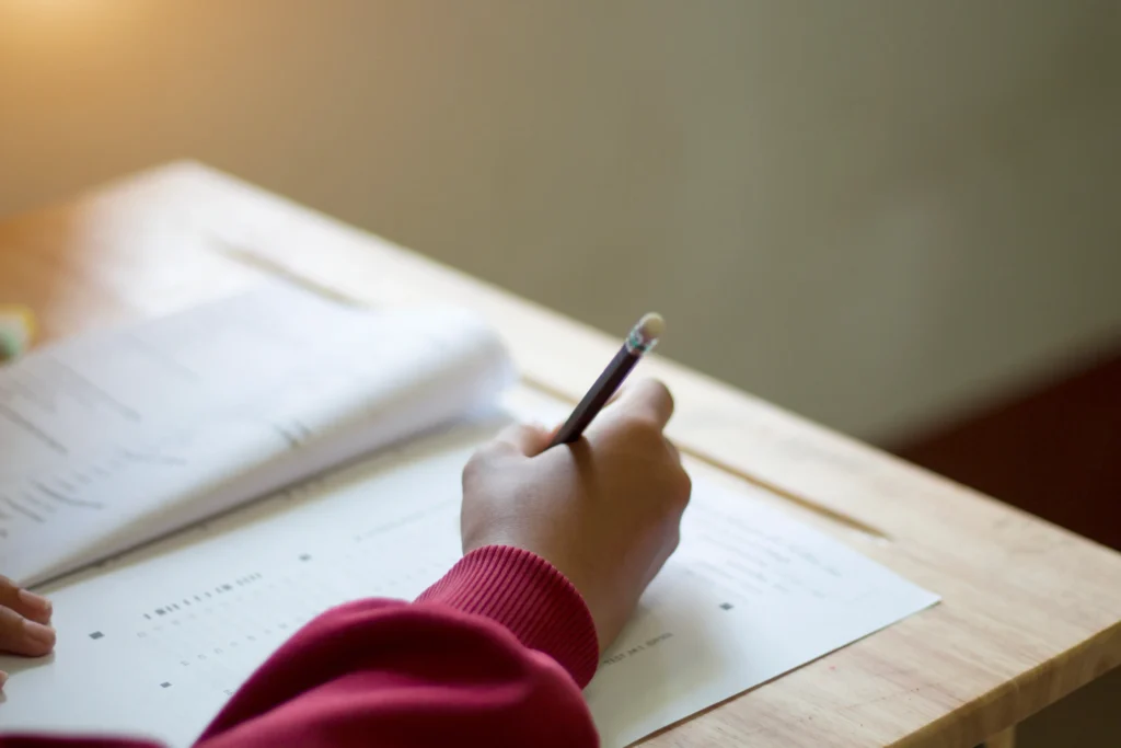 Estudante de uniforme fazendo teste na sala de aula