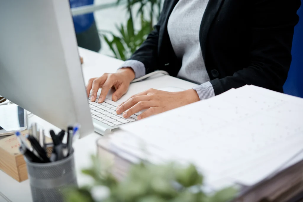 Mulher sentada na mesa do escritório digitando no teclado