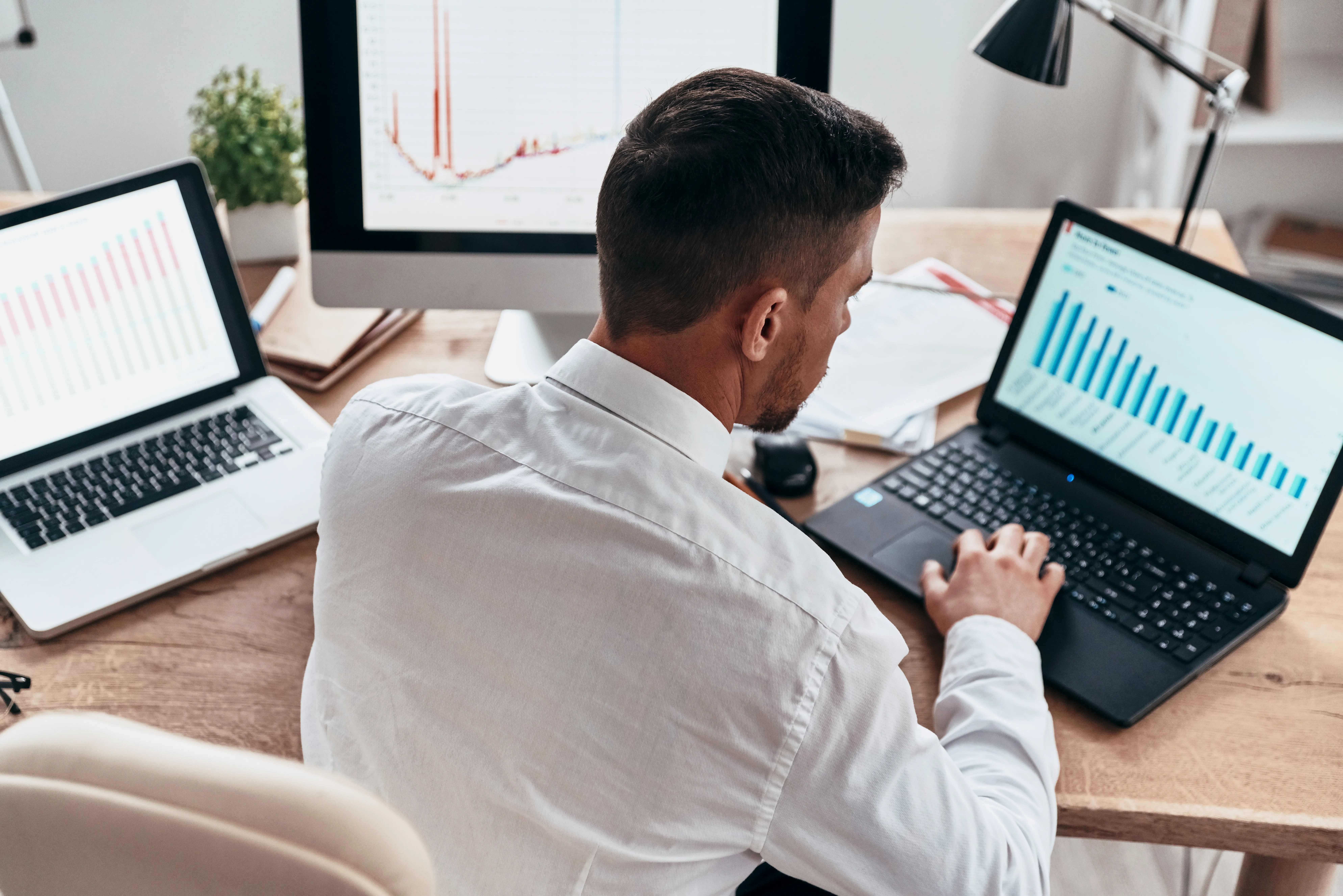 Empresário analisando dados usando o computador enquanto está sentado no escritório