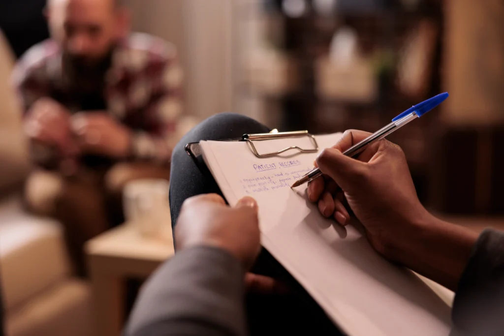 Psicólogo tomando notas na sessão de terapia