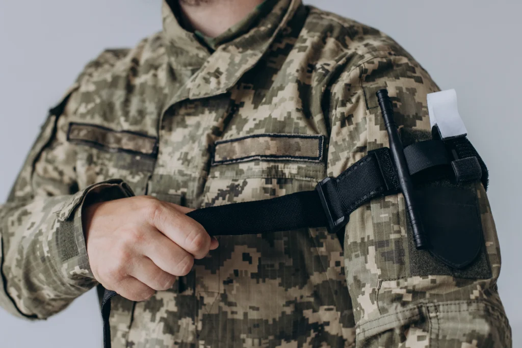 Um militar demonstrando um torniquete